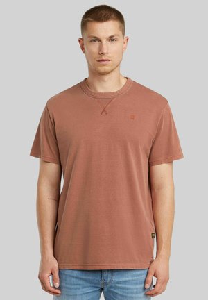 Korte mouwen roestkleurige t-shirt van katoen met een ronde hals, subtiele kruissteeking en een klein merkembleem op de borst.