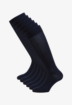Calcetines azul marino hasta la rodilla, hechos de un material suave y elástico, con un puño acanalado y punta reforzada para mayor durabilidad. Se exhiben seis pares.