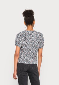 Blusa a maniche corte con un motivo floreale scuro e accenti rosa e verdi. Tessuto morbido con silhouette aderente e scollatura rotonda.