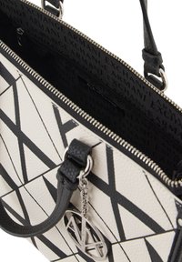 Borsa a tracolla bianca in pelle con pattern geometrici neri, hardware in argento e impugnatura testurizzata. Dotata di chiusura con zip e tasca interna.