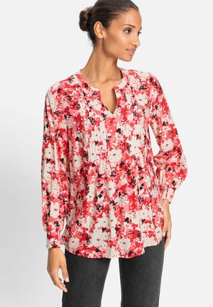 Blumenbluse in Rot-, Rosa- und Weißtönen; mit rundem Halsauschnitt, Falten und langen Ärmeln mit elastischen Bündchen. Weicher, strukturierten Stoff.