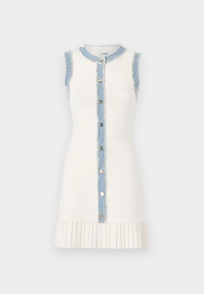 Ujj nélküli fehér ruha, elhasználódott farmer panellel és gombos záródással elöl, redőzött alsó szegéllyel a textúra érdekében.