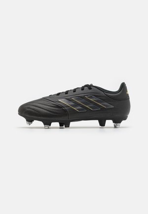 Botín de fútbol negro con parte superior sintética texturizada, que presenta tres rayas metálicas y tachuelas moldeadas para tracción. Logo de acento en el talón.