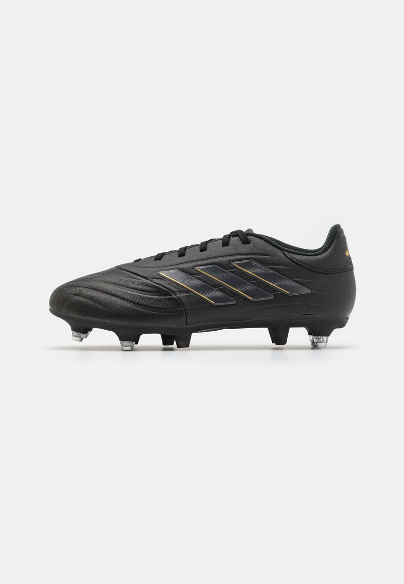 Black football boot with textured synthetic upper, featuring three metallic stripes and molded studs for traction. Accent logo on heel.
