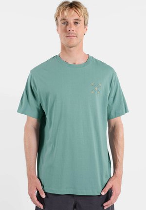 T-shirt en coton vert menthe avec un col rond, des manches courtes et un détail de broderie florale sur la partie gauche de la poitrine.