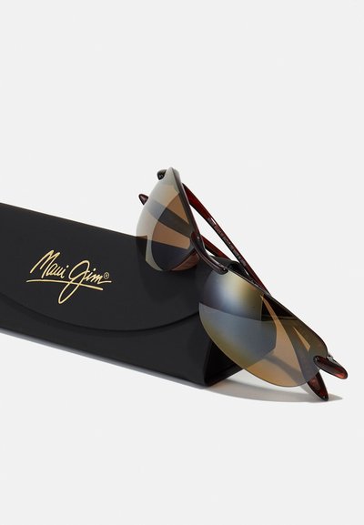 Lunettes de soleil enveloppantes avec verres dégradés, monture en écaille de tortue marron et étui noir avec logo doré. Conception légère pour un confort optimal.
