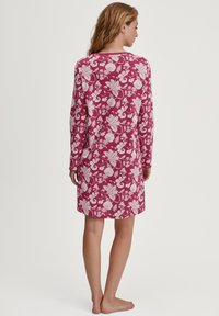 Camicia da notte a maniche lunghe in bordeaux con motivo floreale bianco, caratterizzata da una vestibilità comoda e un tessuto morbido, che termina a metà coscia.