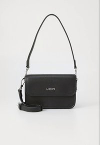 Mala transversal de couro preto com design estruturado, fecho de aba magnético, ferragens prateadas e alça ajustável. Apresenta o logótipo da marca.