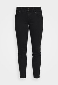 Jeans ajustados negros para mujer con dos botones, bolsillos frontales y patas de tobillo, sobre un fondo blanco.
