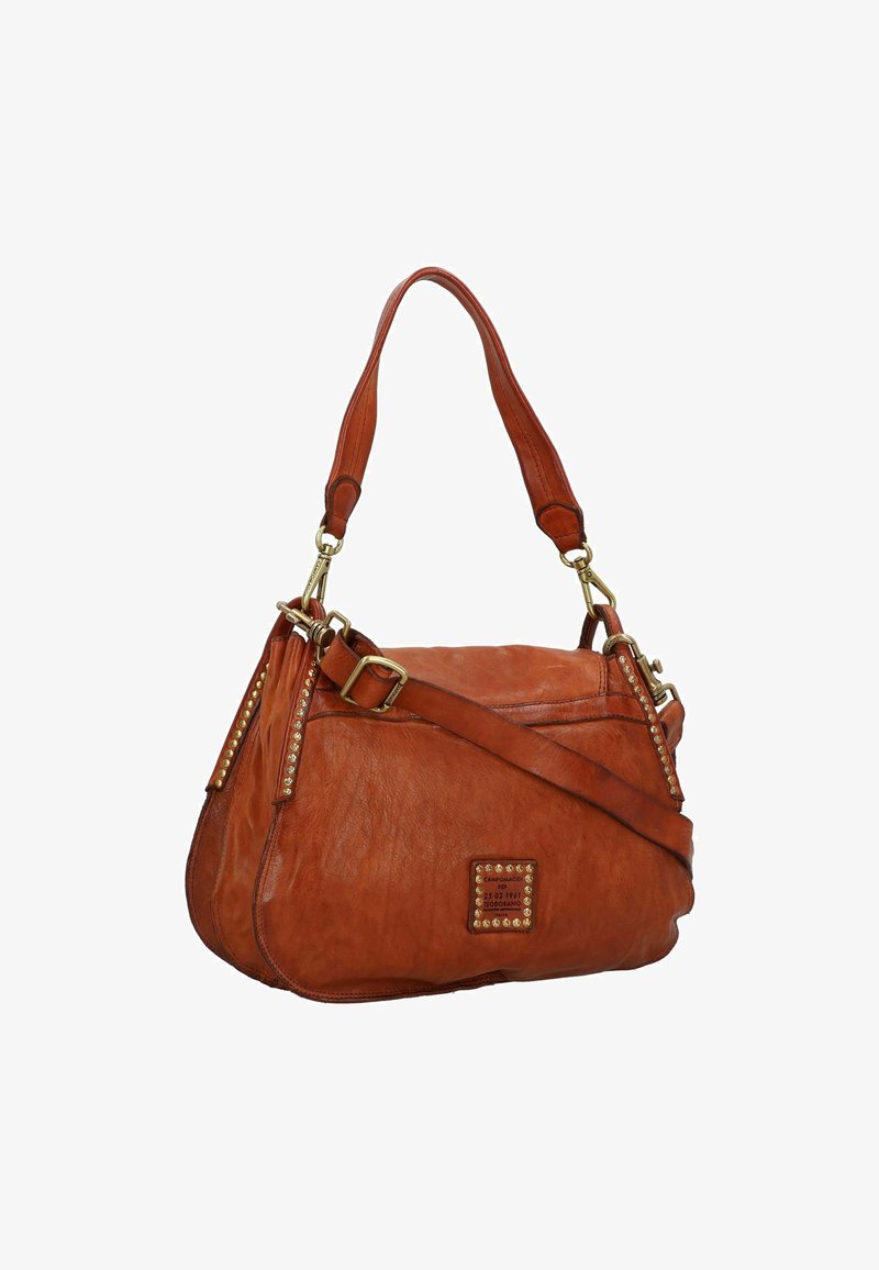 Borsa a tracolla di pelle colorata in tan con un design morbido, hardware dorato e dettagli con borchie. Presenta sia una tracolla che un'opzione a bandoliera.
