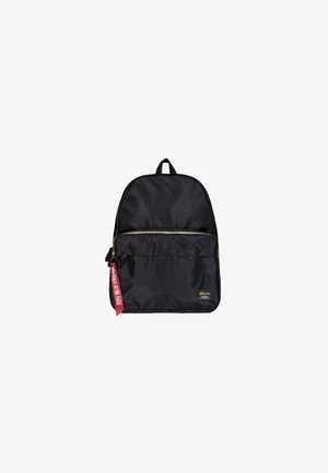 Mochila de nylon preta com um design arredondado, bolso frontal com fecho, uma pega superior e um puxador de zíper em vermelho com a marca. Detalhe em hardware dourado no zíper.