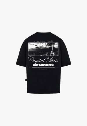 Black t-shirt featuring a graphic print of the Eiffel Tower and text "Crystal Paris Champs" in white at the back. Short sleeves and relaxed fit.