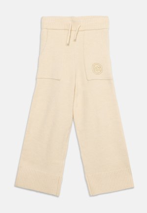 Fløjlsfarvede bredbenede strikkede bukser med ribmanchetter, elastik i taljen, snøre og to forlommer, hvoraf den ene har et broderet logo.