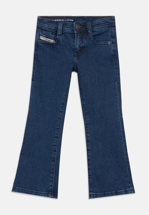 Jean évasé bleu foncé avec fermeture par bouton et zip, poches avant et petite étiquette de marque sur la poche avant droite.