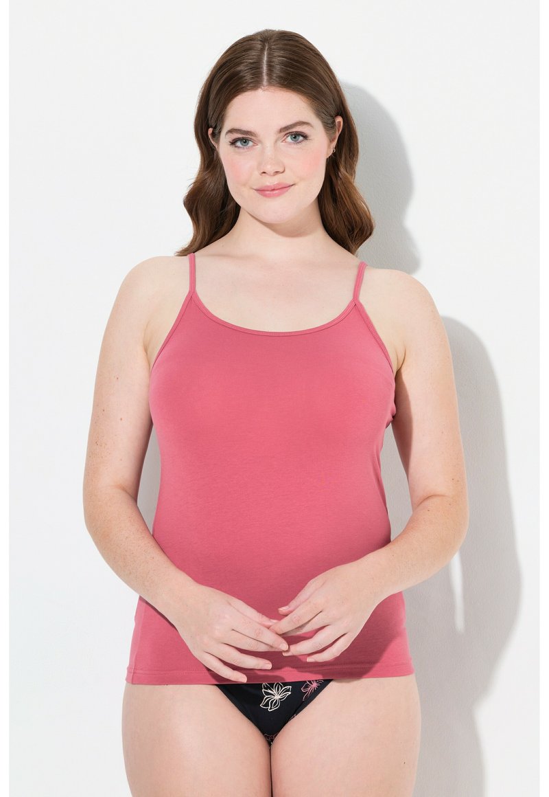 Camisola rosa aderente con spalline sottili. Indossata con biancheria intima nera con ricami floreali. Tessuto liscio, che arriva all'anca.