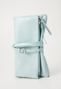 Clutch in finta pelle blu chiaro con finitura texturizzata, forma rettangolare, chiusura con zip e dettaglio decorativo a cintura avvolto attorno.