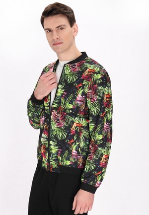 Giacca bomber con una stampa di foglie tropicali colorate in verde, rosa e nero. Materiale robusto con polsini a coste e chiusura con zip.