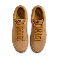 Brune lær sneakers med perforeret tåboks, flade snørebånd og gummisål. Har et sort Nike-logo på tungen og siden.
