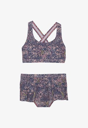 Kwiatowy zestaw bikini na granatowym tle z różowymi, żółtymi i białymi kwiatami. Góra ma skrzyżowane ramiączka; szorty mają rozkloszowany krój.