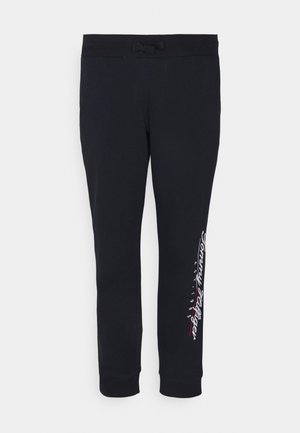 Pantalon de jogging noir avec taille à cordon, jambes fuselées, et un logo blanc et rouge imprimé le long de la jambe gauche. Texture de tissu douce.