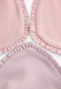 Three fabric placemats in light pink and lavender, featuring a ruffled edge with a smooth texture and subtle heathered pattern.