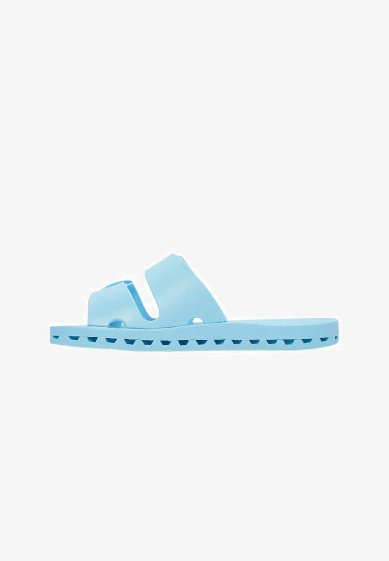 Sandalia de-slide azul claro hecha de plástico suave, con dos correas anchas y una suela texturizada con pequeños agujeros de drenaje.