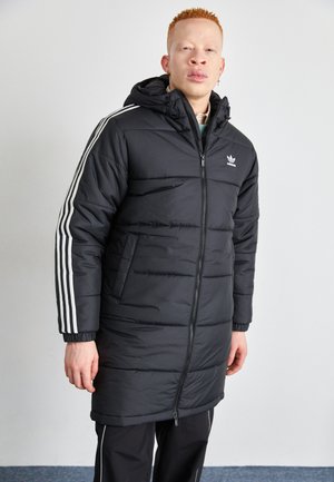 Czarna kurtka puchowa z zamkiem z przodu, z białymi paskami na rękawach, kapturem i elastycznymi mankietami. Logo Adidas na klatce piersiowej.