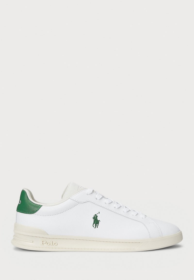Vita lädersneakers med grön detalj på hälen, som har en grön logotyp och platt gummisula med texturerad detalj.