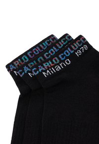 Sorte sokker med farverig tekst på kanten, der lyder "COLUCCI MILANO 1978." Teksturen er glat og strikket med en tætsiddende pasform.