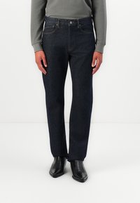 Dark blue denim jeans with a straight leg design, featuring five pockets, belt loops, and a classic button closure. Texture is smooth.