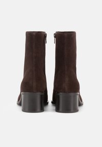 Brązowe botki ze skóry zamszowej o gładkim wykończeniu, z zamkiem z tyłu i masywnym czarnym obcasem. Prosty i elegancki design.