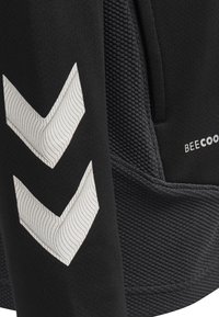 Indumento sportivo nero con tessuto texturizzato, motivo a chevron bianco e il marchio "BEECOOL" visibile sul lato.