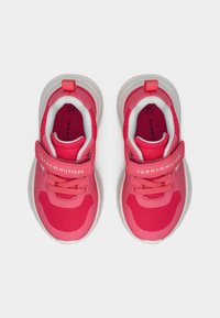 Ροζ αθλητικά παπούτσια με ύφασμα διχτυωτό στο πάνω μέρος, λευκές λεπτομέρειες, με αυτοκόλλητο ιμάντα και μαλακή σόλα. Φέρουν το λογότυπο της μάρκας στον ιμάντα και στην εσωτερική σόλα.