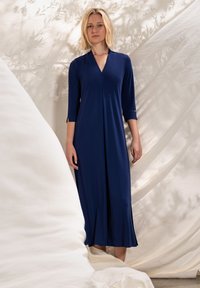 Donkerblauwe, knielange jurk van gladde stof, met een V-hals, driekwart mouwen en een losse pasvorm met een uitlopende zoom.
