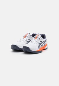 Baskets blanches avec des accents navy et des détails orange. Comprennent une tige en maille texturée, des lacets et une semelle en caoutchouc robuste avec une bonne accroche.