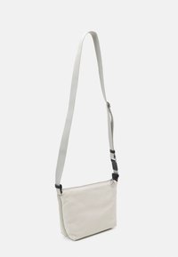 Lichtgrijze schoudertas gemaakt van gestructureerde stof, met een lange verstelbare schouderband en een ritssluiting. Simpel en rechthoekig ontwerp.