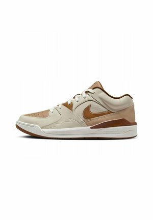 Beige en bruine lage Nike sneaker met witte veters, geperforeerde neus en dikke witte zool met bruine accenten.