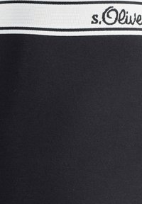 Black leggings featuring a white and black striped waistband with the brand name "s.Olive" in a cursive font. Smooth, stretchy material.