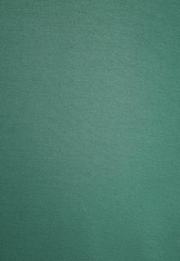 Tealfärgad bomullstyg med en slät, något texturerad yta, som har en enhetlig färg och inga synliga mönster eller dekorationer.