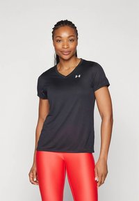 Black short-sleeve athletic shirt with a V-neck design and a small white logo. Smooth texture. Paired with bright red leggings.