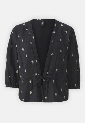 Blusa negra ligera de corte holgado, con cintura ajustable mediante cordón y mangas tres cuartos, que presenta patrones en forma de diamante blancos y un frente abierto.