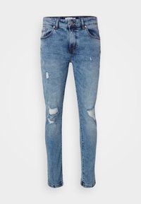 Jeans de mezclilla azul claro con un diseño ajustado, que cuentan con detalles rasgados en las rodillas, un sutil desgaste y el estilo clásico de cinco bolsillos.