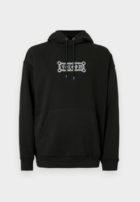 Sudadera negra con bolsillo frontal, capucha ajustable con cordón y diseño gráfico en texto blanco. Hecha de una tela suave y texturada.