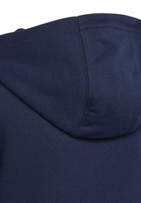 Felpa con cappuccio blu navy realizzata in un tessuto morbido e texturizzato, con cappuccio rotondo e una finitura liscia caratterizzata da cuciture dettagliate sulle giunture.