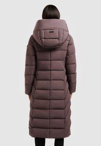 Duga ljubičasta puffer jakna s velikim kapuljačom, kvadratnim krojem i bočnim džepovima. Glatka tekstura s elegantnim siluetom, koja se proteže do sredine lista.