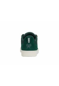 Sneaker verde in suede con suola in gomma bianca, logo di racchette da tennis ricamato e linguetta sul tallone testurizzata. Design minimalista con accenti sottili.