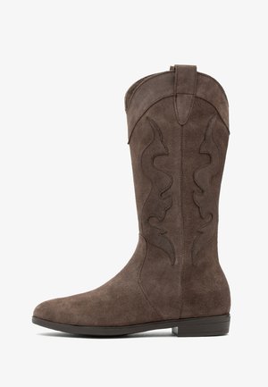 Barna suede cowboy csizmák magas szárakkal, hullámos mintázatú díszvarrással és lapos gumitalppal. Részletes varrás a felső részen.