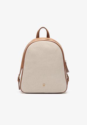 Beige stoffen rugzak met bruine leren accenten, ronde vorm, handvat aan de bovenkant en ritsclosure. Gouden logo-detail onderaan in het midden.