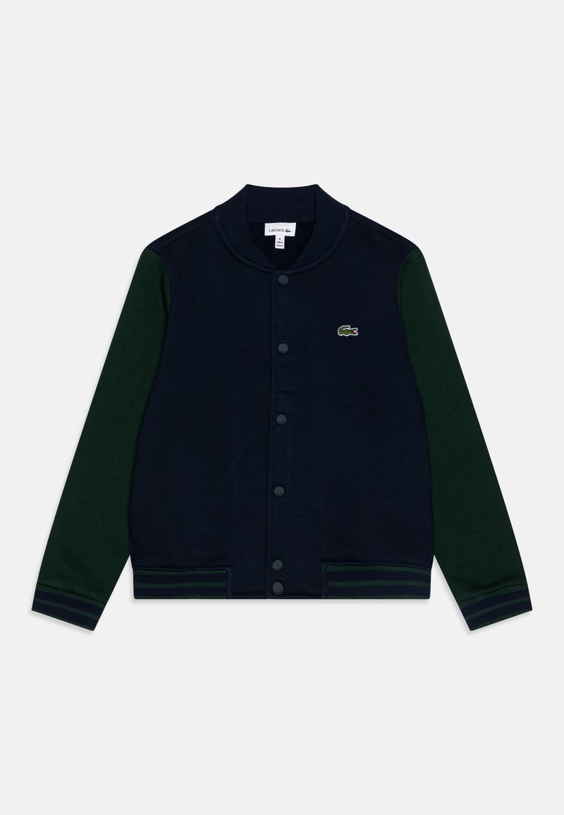 Giacca varsity blu navy con maniche verdi, polsini e vita a costine. Presenta chiusura a bottoni e logo ricamato sul petto.