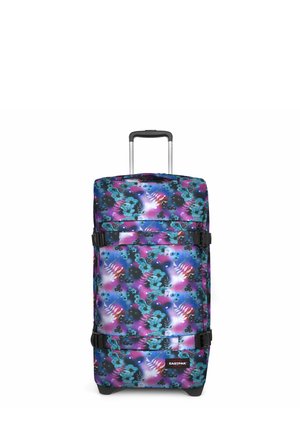 Spinner suitcase with vibrant floral pattern in blue, pink, and purple. Features black straps, a telescopic handle, and wheels.